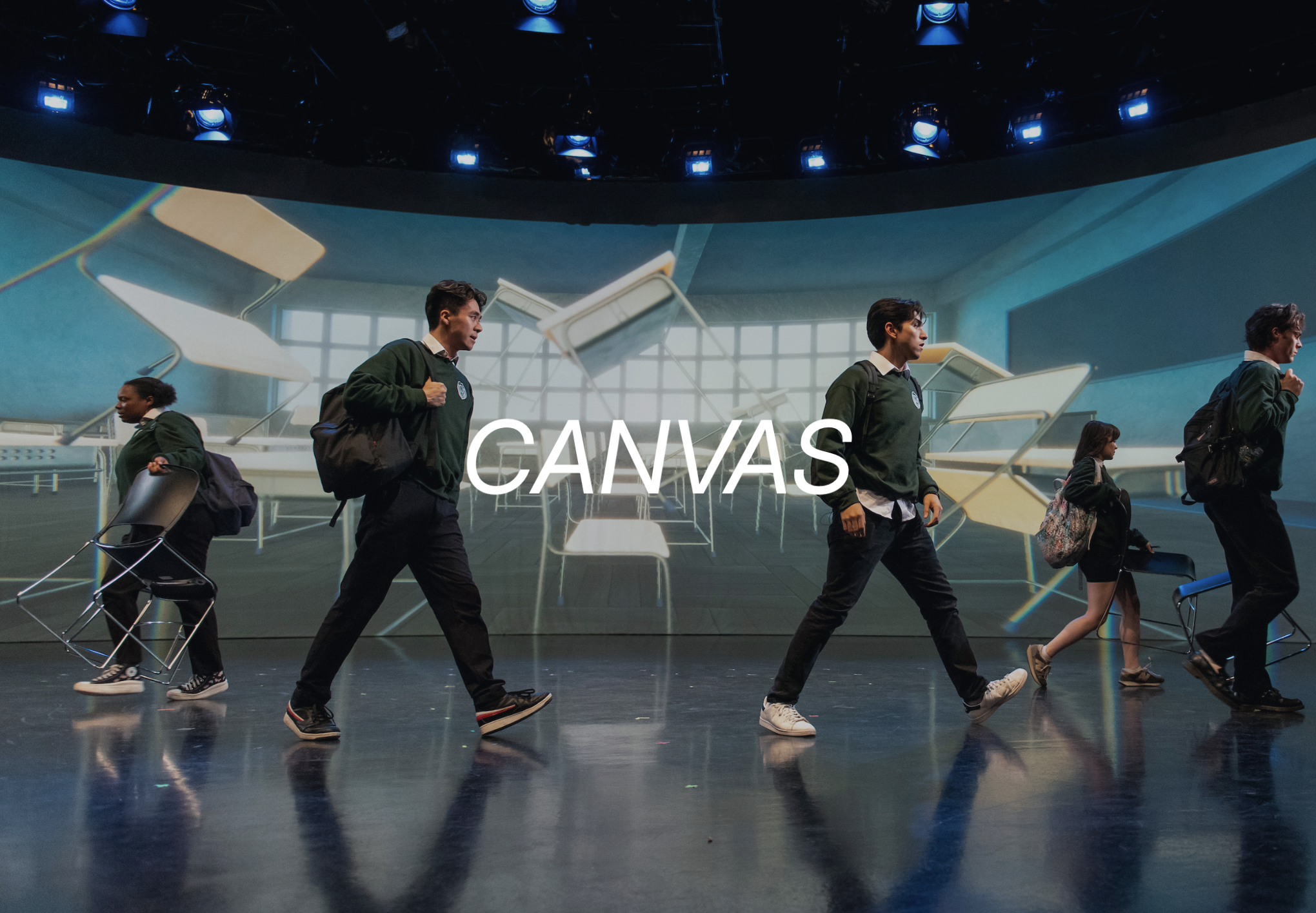 Canvas (Cover Image: a cool-lit scene, showing students dramatically walking across a blackbox space. A projection screen upstage shows a classroom space with desks and chairs floating upwards)